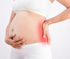 Pregnant woman with a strong pain massaging her backache pain in red